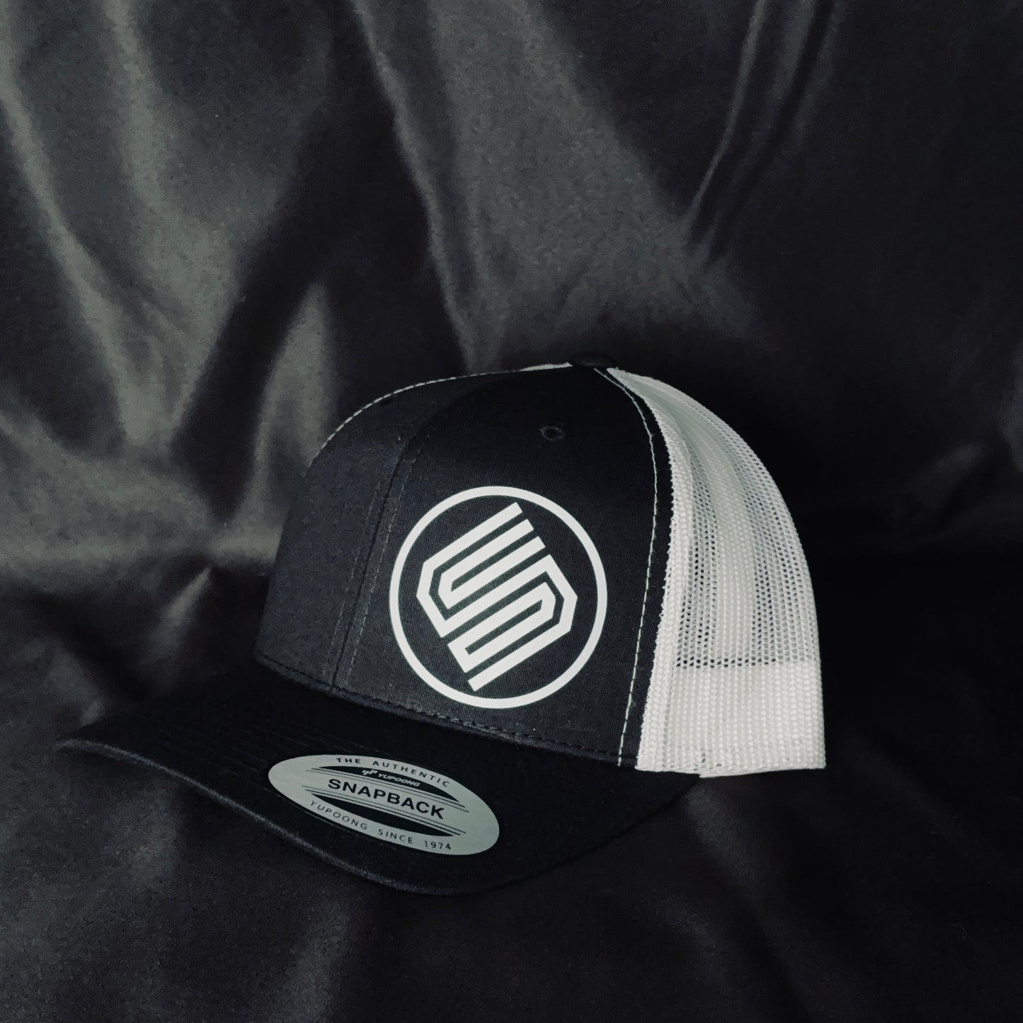 Black and white snapback Coming On Strong snapback hat on black background. 